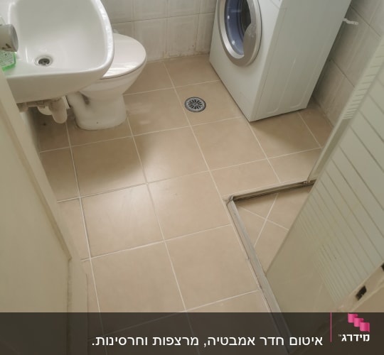 חדר אמבטיה עם מכונת כביסה וכיור